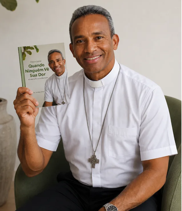 Padre Vanilson Silva segurando o devocional Quando Ninguém Vê Sua Dor